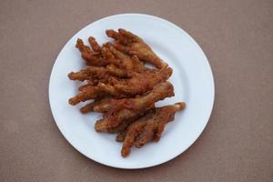 White plate of crispy fried chicken feet. Top veiw. Concept, weird, exotic food. delicious and popular street food in Thailand photo