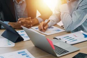 Financial analysts analyze business financial reports on a digital tablet planning investment project during a discussion at a meeting of corporate showing the results of their successful teamwork. photo