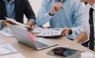 Financial analysts analyze business financial reports on a digital tablet planning investment project during a discussion at a meeting of corporate showing the results of their successful teamwork. photo