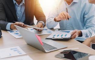 Financial analysts analyze business financial reports on a digital tablet planning investment project during a discussion at a meeting of corporate showing the results of their successful teamwork. photo