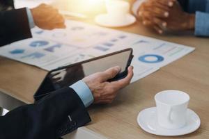 Financial analysts analyze business financial reports on a digital tablet planning investment project during a discussion at a meeting of corporate showing the results of their successful teamwork. photo