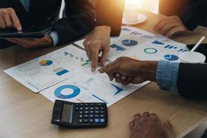 Financial analysts analyze business financial reports on a digital tablet planning investment project during a discussion at a meeting of corporate showing the results of their successful teamwork. photo