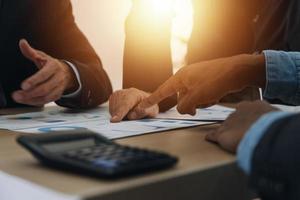 Financial analysts analyze business financial reports on a digital tablet planning investment project during a discussion at a meeting of corporate showing the results of their successful teamwork. photo