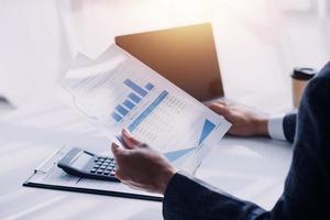 Financial analysts analyze business financial reports on a digital tablet planning investment project during a discussion at a meeting of corporate showing the results of their successful teamwork. photo