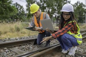 Two engineer working at train station,Work together happily,Help each other analyze the problem,Consult about development guidelines photo