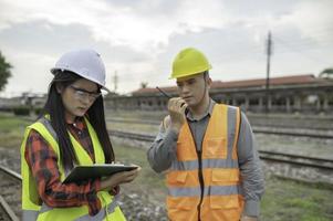 Two engineer working at train station,Work together happily,Help each other analyze the problem,Consult about development guidelines photo