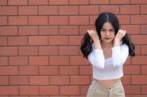 Portrait of hipster girl  on brick wall background,Beautiful asian woman pose for take a photo,Kawaii style photo