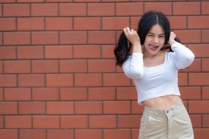 Portrait of hipster girl  on brick wall background,Beautiful asian woman pose for take a photo,Kawaii style photo