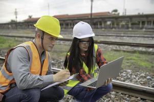 Two engineer working at train station,Work together happily,Help each other analyze the problem,Consult about development guidelines photo