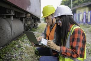 Two engineer working at train station,Work together happily,Help each other analyze the problem,Consult about development guidelines photo