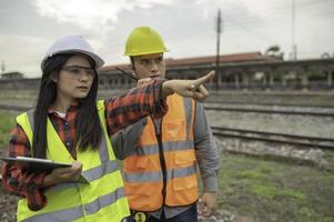 Two engineer working at train station,Work together happily,Help each other analyze the problem,Consult about development guidelines photo