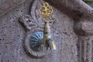 Old copper faucet in a public place on the street of the old city in Turkey, travel time, idea for background photo