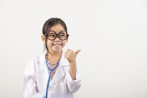 Asia pequeño niña jugando médico aislado en blanco foto