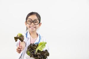 Asia pequeño niña jugando médico aislado en blanco foto