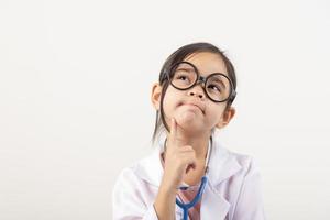 Asia pequeño niña jugando médico aislado en blanco foto