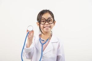 Asia pequeño niña jugando médico aislado en blanco foto