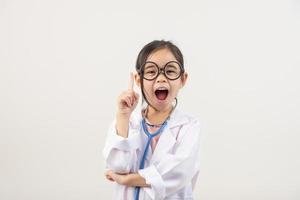 Asia pequeño niña jugando médico aislado en blanco foto