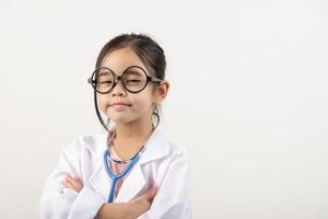 Asia pequeño niña jugando médico aislado en blanco foto