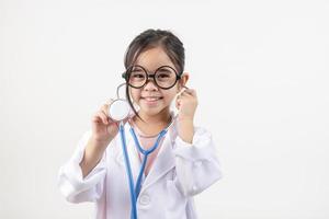 Asia little girl playing doctor isolated on white photo