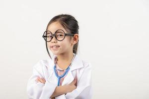 Asia pequeño niña jugando médico aislado en blanco foto