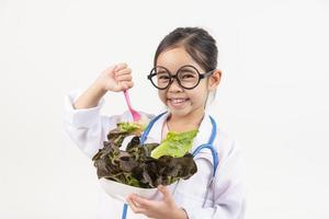 Asia pequeño niña jugando médico aislado en blanco foto