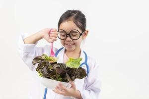 Asia pequeño niña jugando médico aislado en blanco foto