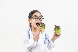 Asia pequeño niña jugando médico aislado en blanco foto