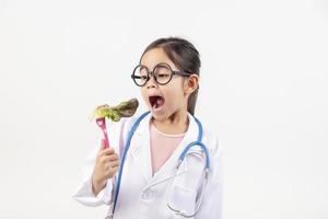 Asia little girl playing doctor isolated on white photo