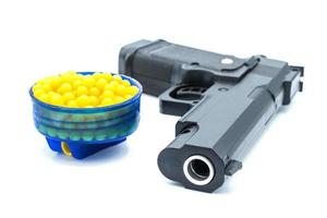 Air gun with plastic bullet on isolated background. Air guns are designed to shoot BBs, pellets or sometimes both using air-powered propulsion such as CO2 or pre-charged pneumatic air tanks. photo