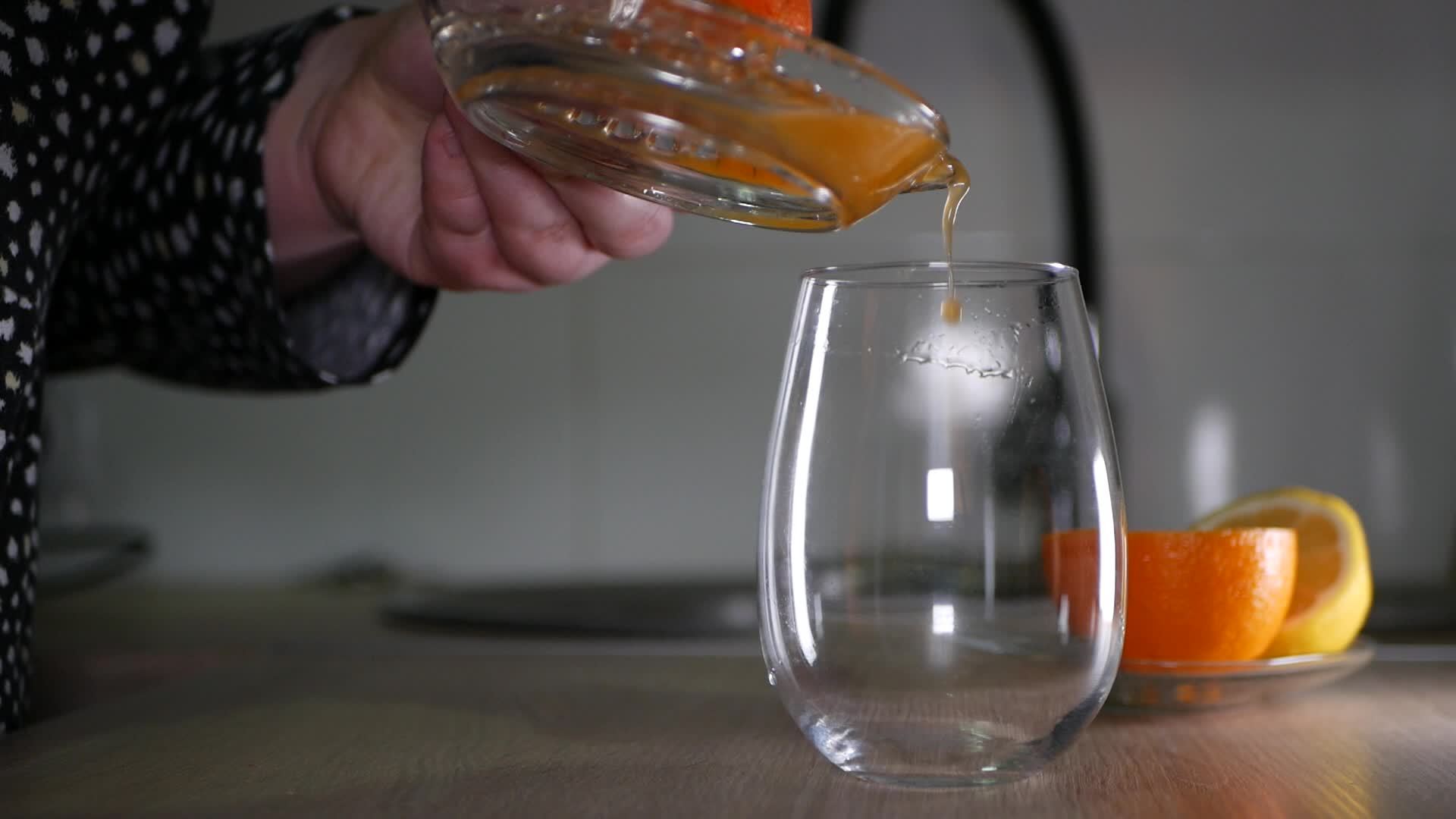 Pouring freshly squeezed tangerine juice into a glass 20514880 Stock