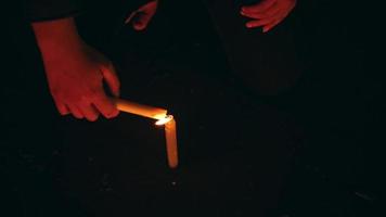 the hands of a woman lighting a candle in the dark before performing a ritual video