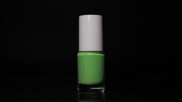 Green neon nail polish on black background video