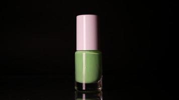 Green neon nail polish on black background video