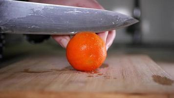 cortar Mandarina de cerca en un de madera tablero video