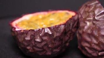 Passion fruit close-up on a black background rotates video