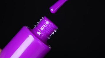 Purple neon nail polish on black background video