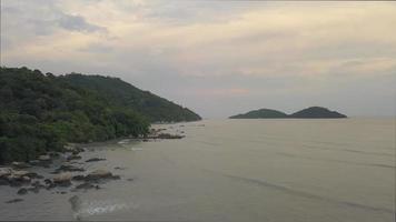 Aerial fly over coastal rock stone during sunset. video