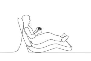 man lies in a massage chair with a gaming device - one line drawing vector. concept to play video games comfortably vector