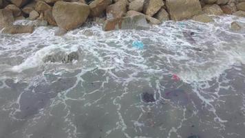 Waves of rubbish washing onto rock video