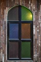 Retro-style wooden windows use stained glass to decorate the window niches for a colorful and classic look that makes the window interesting and eye-catching. photo