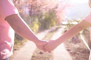 male and female couple holding hands to show friendship, love and concern because holding hands is a symbol of couple love. Male and female couple express their love by holding hands. photo
