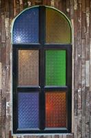 Retro-style wooden windows use stained glass to decorate the window niches for a colorful and classic look that makes the window interesting and eye-catching. photo