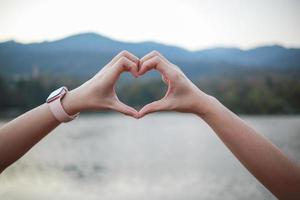 masculino y hembra Pareja demostración su manos arriba a formar corazón símbolo a espectáculo amistad amor y amabilidad porque corazón es símbolo de amor. masculino y hembra Pareja demostración su amor con corazón símbolo foto