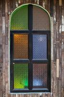 Retro-style wooden windows use stained glass to decorate the window niches for a colorful and classic look that makes the window interesting and eye-catching. photo