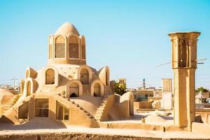 Historic castle in Kashan with city buildings background. Explore iran historical heritage concept photo