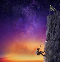 Businessman climb a mountain to get the flag. Achievement business goal and difficult career concept photo