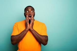 Amazed and shocked expression of a boy over cyan background photo