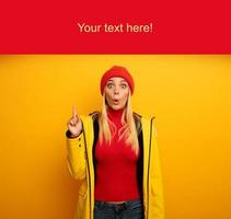 Girl indicates a message above. Amazed and shocked expression. Blank space for your text. Yellow background photo