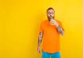 nerd asombrado hombre con lentes bebidas un Fruta jugo foto