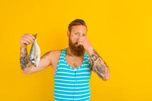 man with beard and swimsuit caught a fish photo